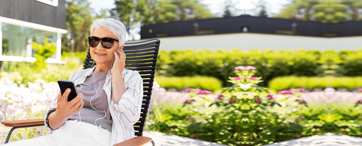 woman listening to podcast in garden