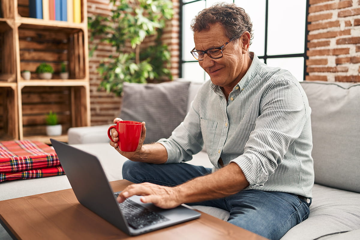 senior with computer and coffee