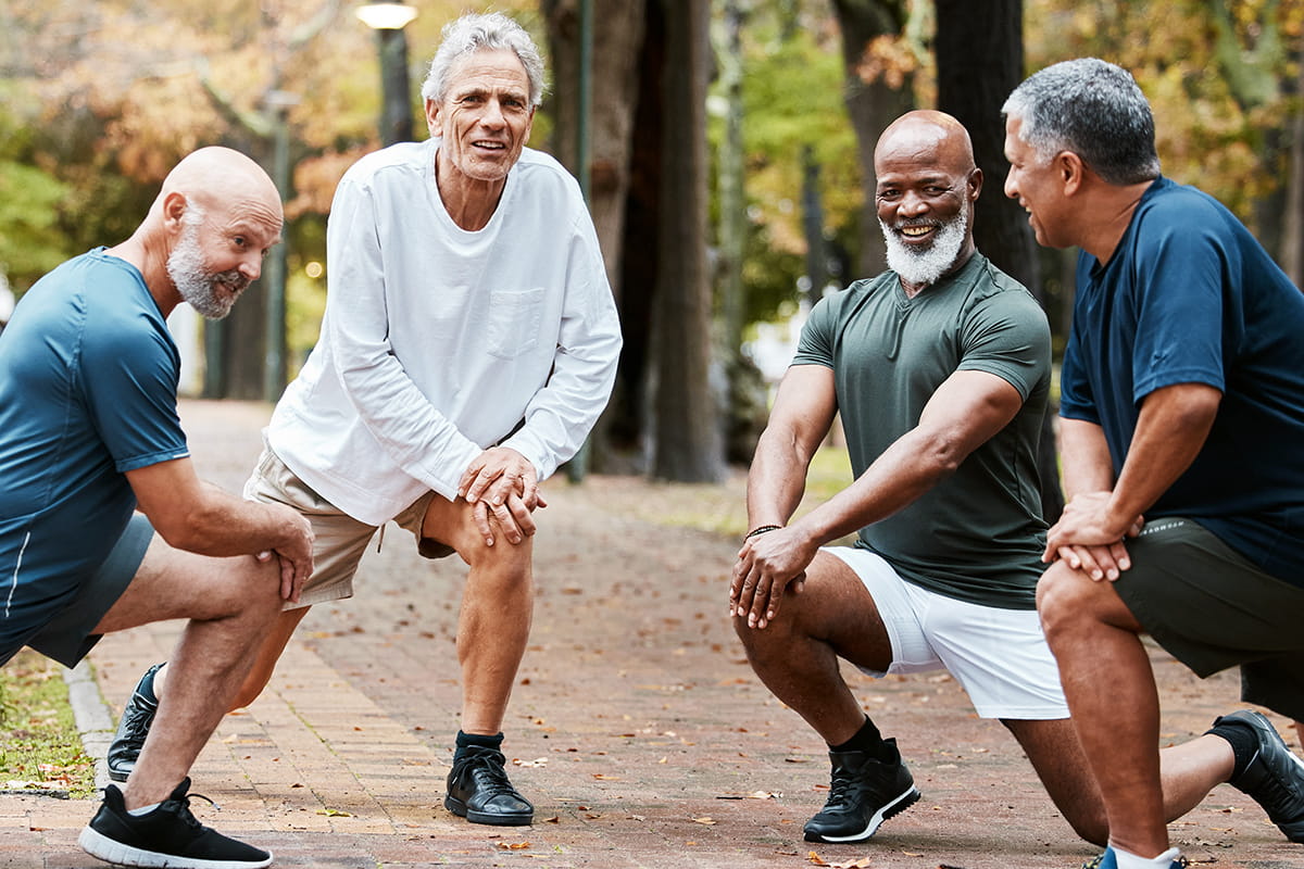 Senior men stretch before jogging outdoors.