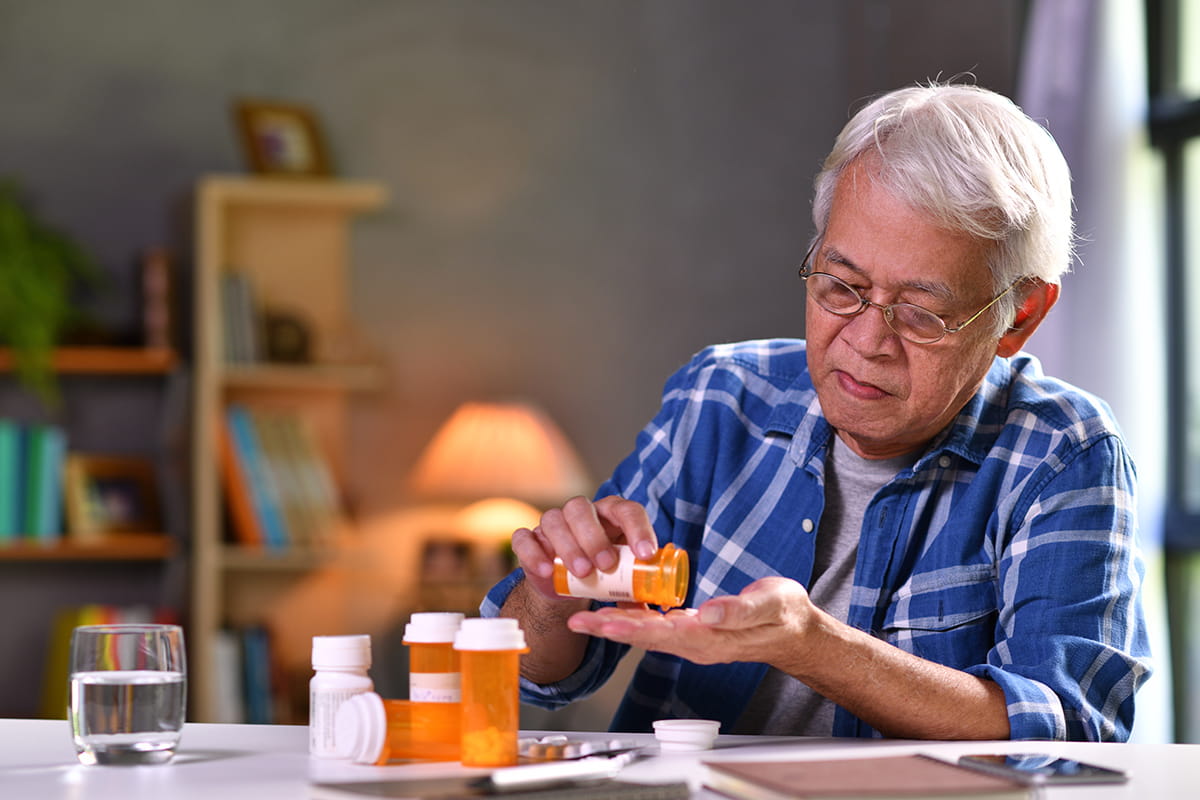 A senior man takes medication.
